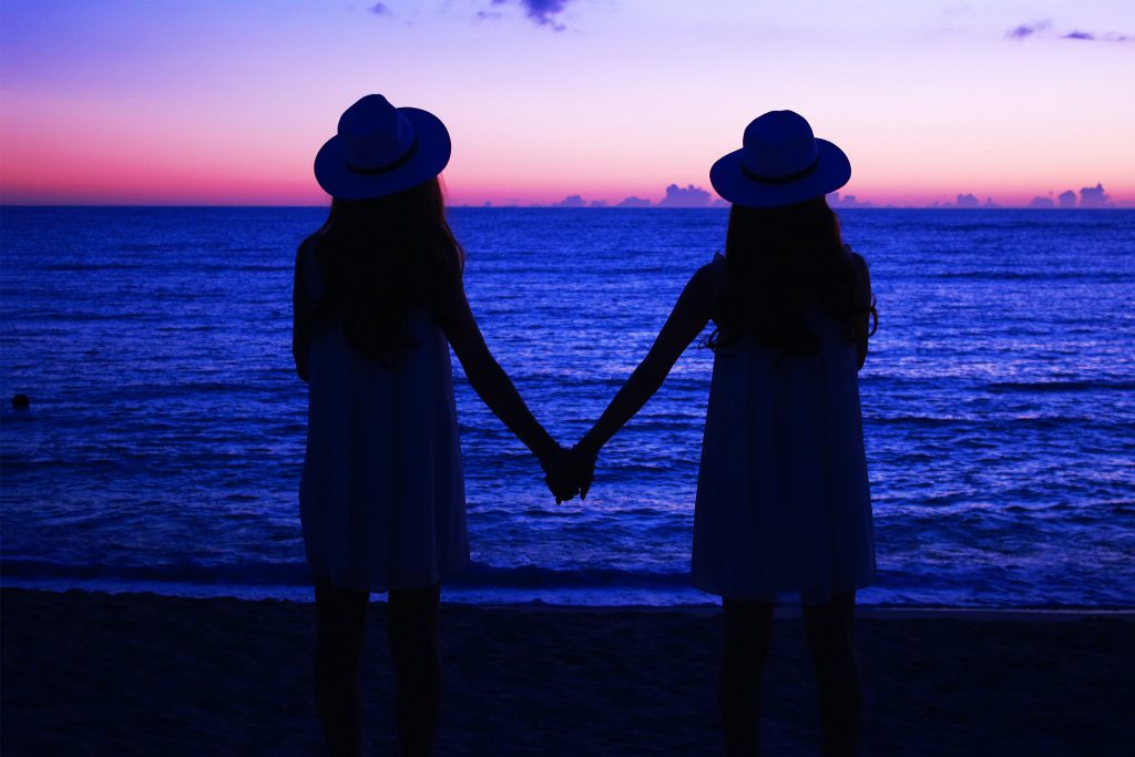 海辺で手を繋ぐ２人の女の子